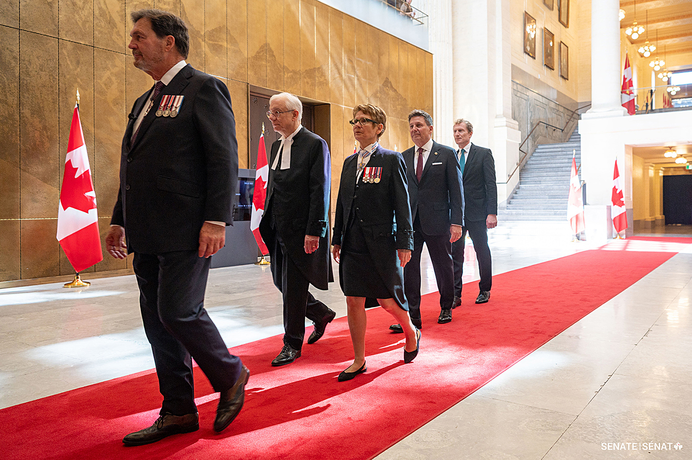 Speaker of the Senate Raymonde Gagné, centre, processes through the Senate of Canada Building on her way to the installation ceremony.