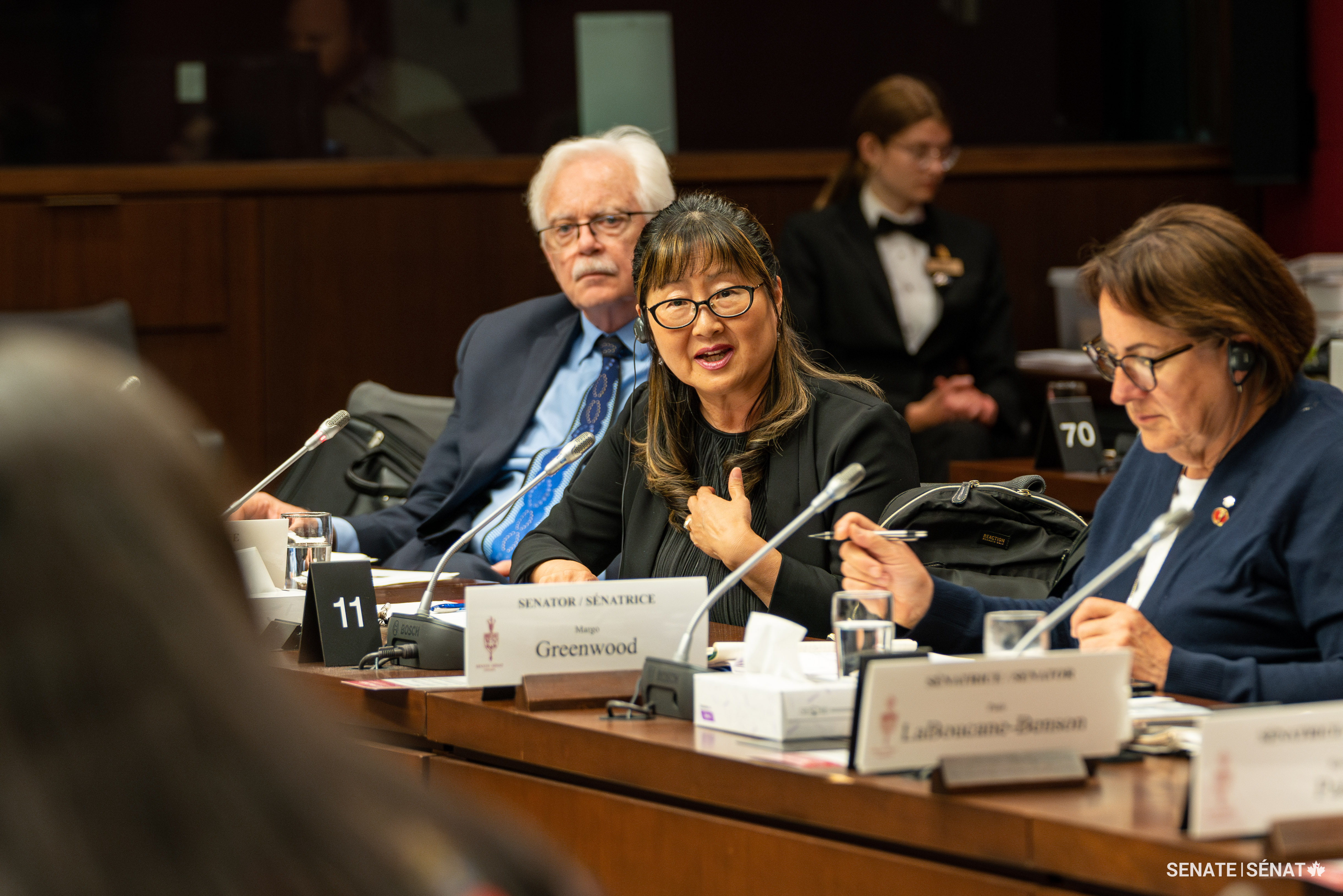 Senator Yonah Martin addresses a youth participant as senators David M. Arnot and Margo Greenwood listen.