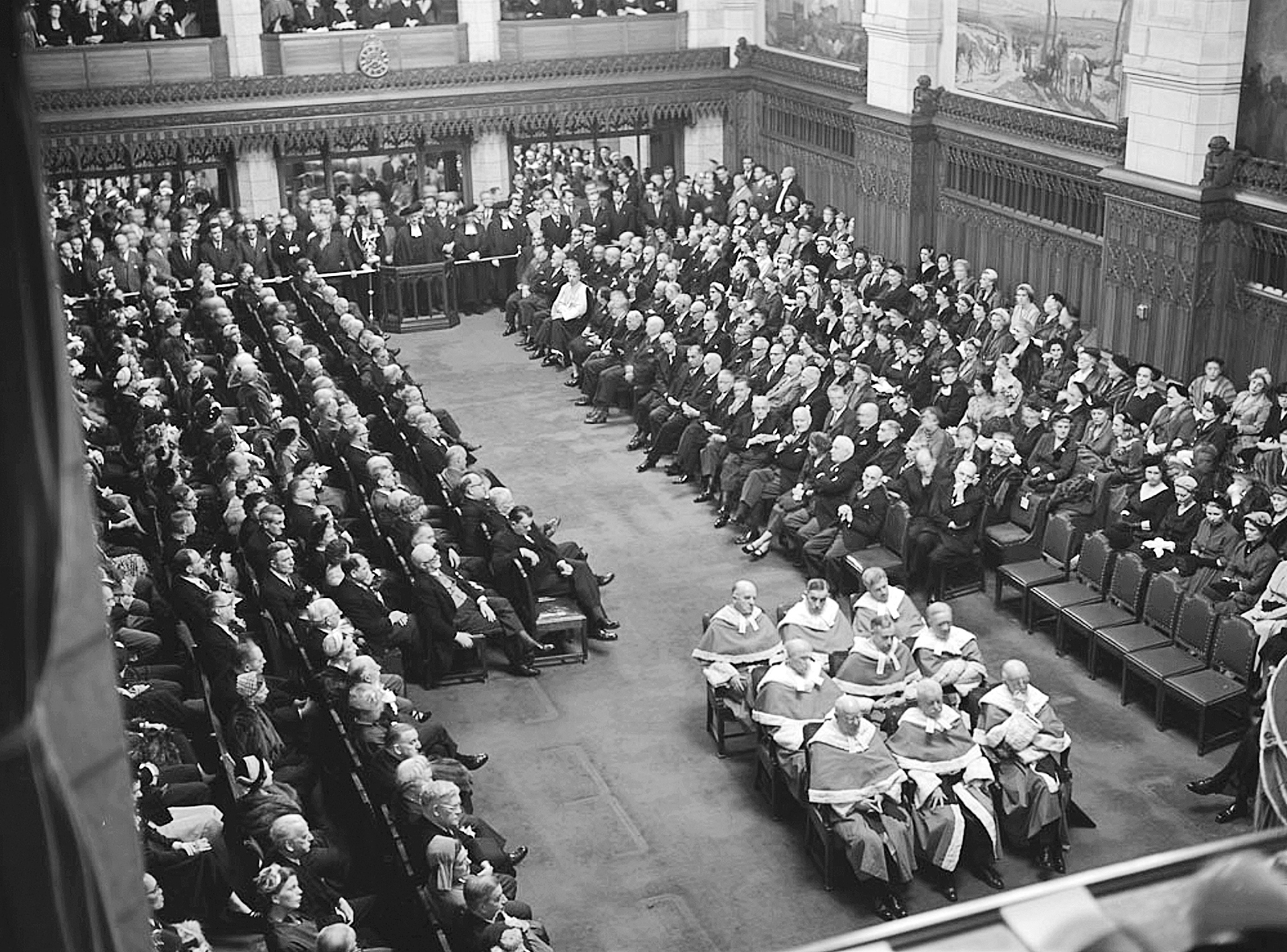 During the opening of the 22nd Parliament in 1953, an expanded roster of nine Supreme Court judges sit on hard-backed chairs, as they have done ever since. (Photo credit: Library and Archives Canada)