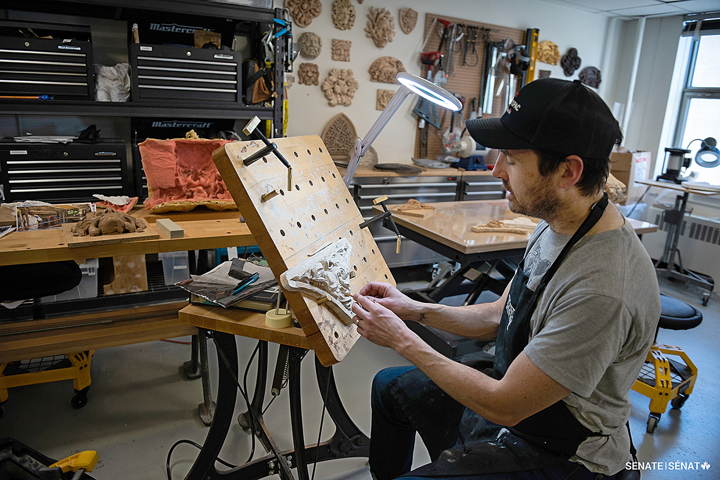 Sculptor Nicholas Thompson adds texture and detail to a plaster maquette of a dragon’s head.