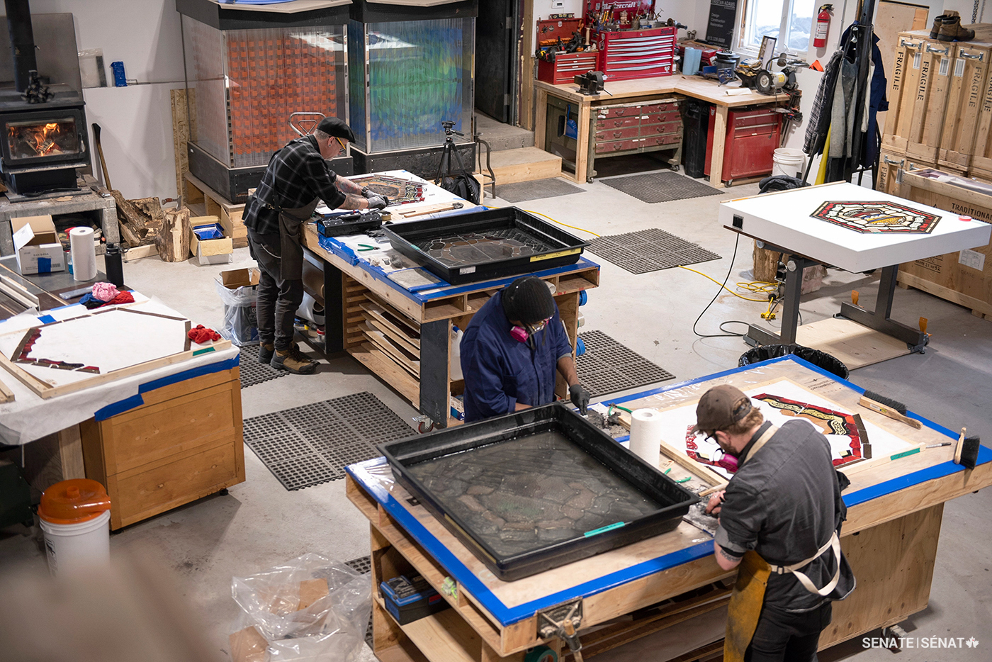 Conservators at Westport, Ontario’s Traditional Glassworks work on various stages of the restoration project. The process starts with soaking the windows in the large black tubs seen here. Each window is taken apart underwater to prevent toxic lead residue from becoming airborne.