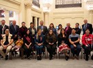 A group of young Indigenous leaders and senators pose in the Senate of Canada Building.