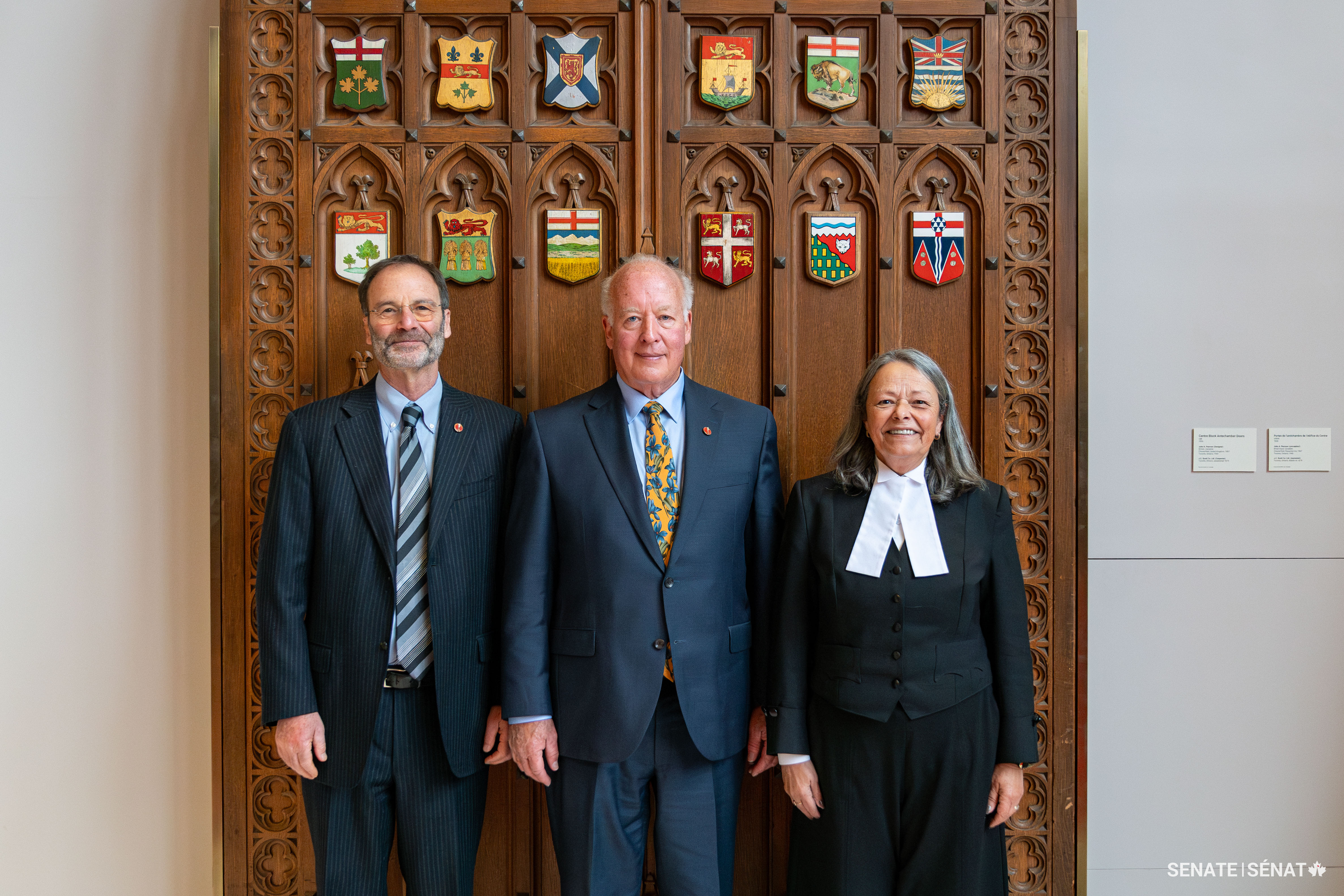 From left, Senator Marc Gold stands with senators John M. McNair and Pierrette Ringuette ahead of Senator McNair’s swearing-in ceremony on November 21, 2023.