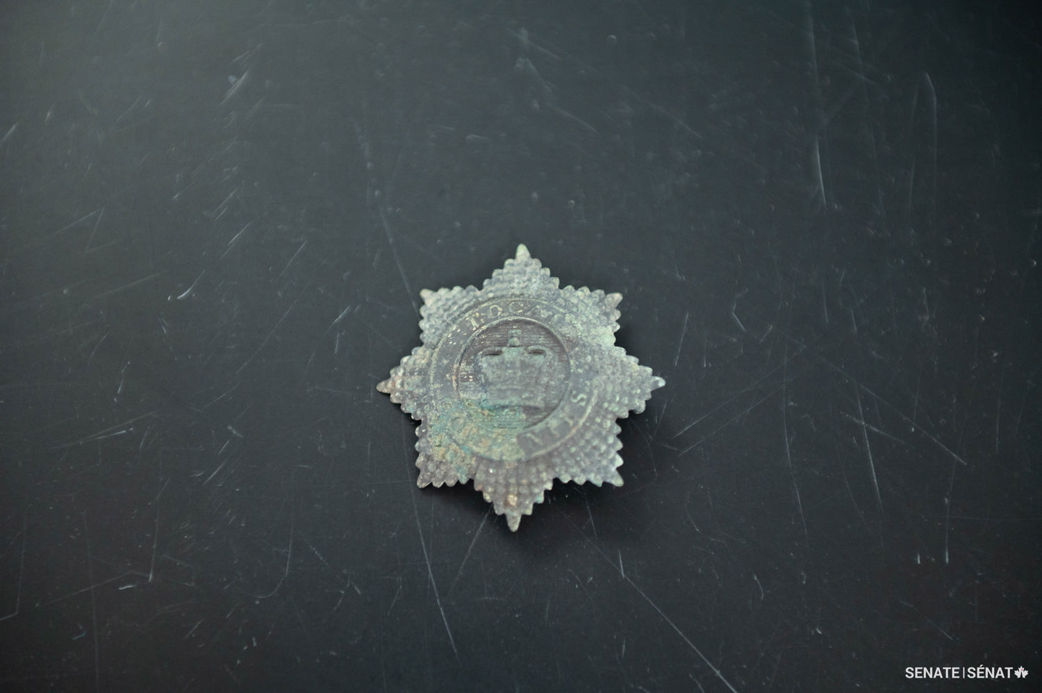 This decorative badge belonged to members of the Enrolled Pensioner Force, a military company stationed on Barrack Hill from 1854 to 1858. The badge attached to the front of the cylindrical hat, called a shako, that military members wore as part of their uniform.