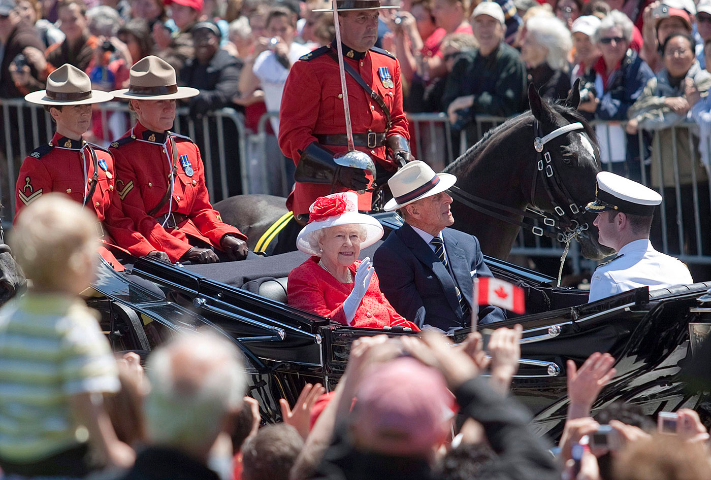 Queen Elizabeth II greets crowds in Ottawa during Canada Day festivities in 2010. Her late husband, Prince Philip, Duke of Edinburgh, sits at her side.