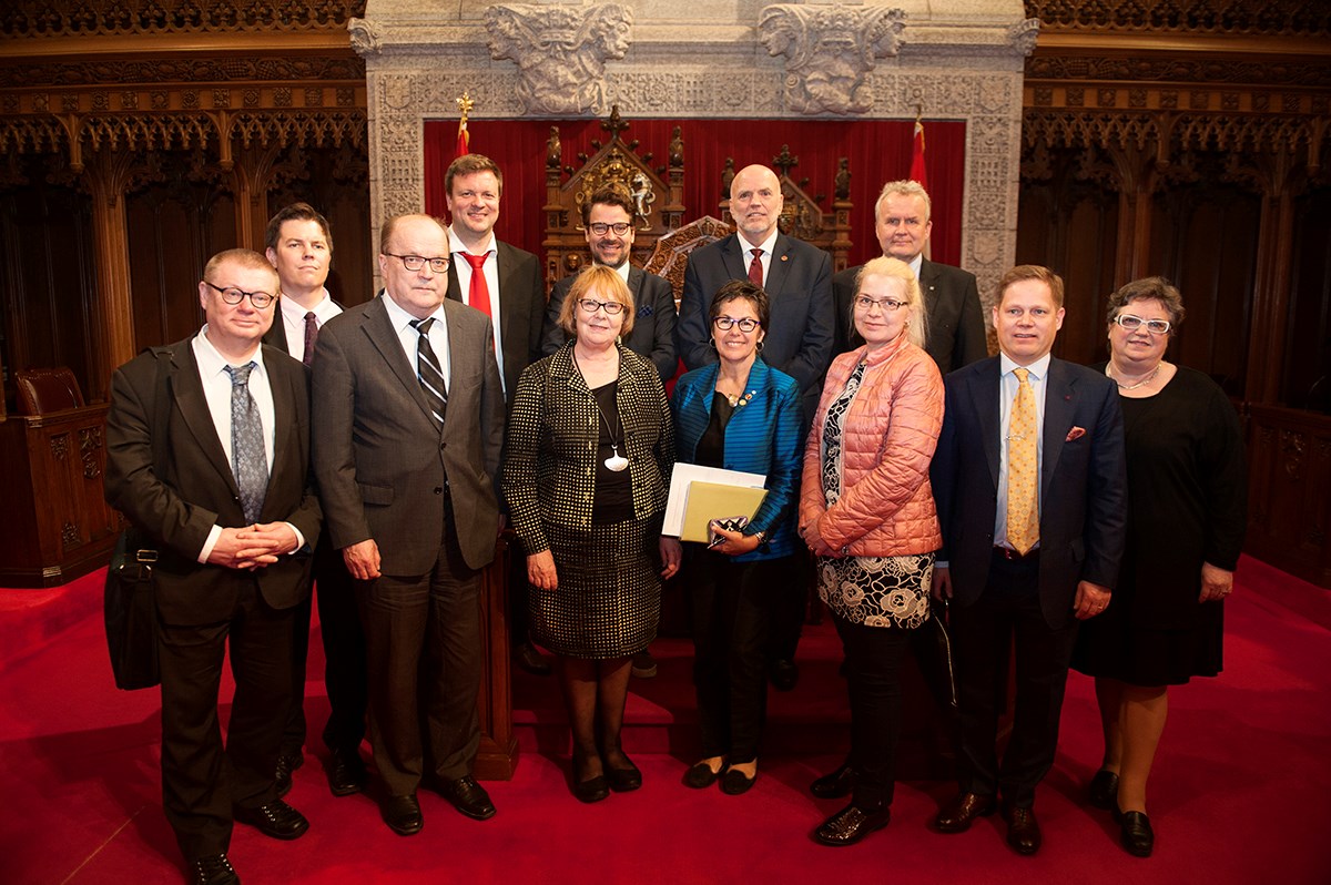 Le sénateur White (dernière rangée, deuxième à partir de la droite) pose avec les membres de la Commission du droit constitutionnel du Parlement de Finlande dans la Chambre rouge dans l’édifice du Centre en 2017. La sénatrice Kim Pate (première rangée, au milieu) apparaît également dans la photo.