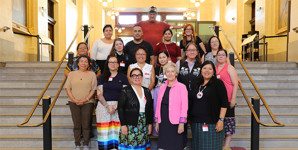Senator Renée Dupuis, centre, front row, and university students in the foyer stairwell of the Senate of Canada Building.