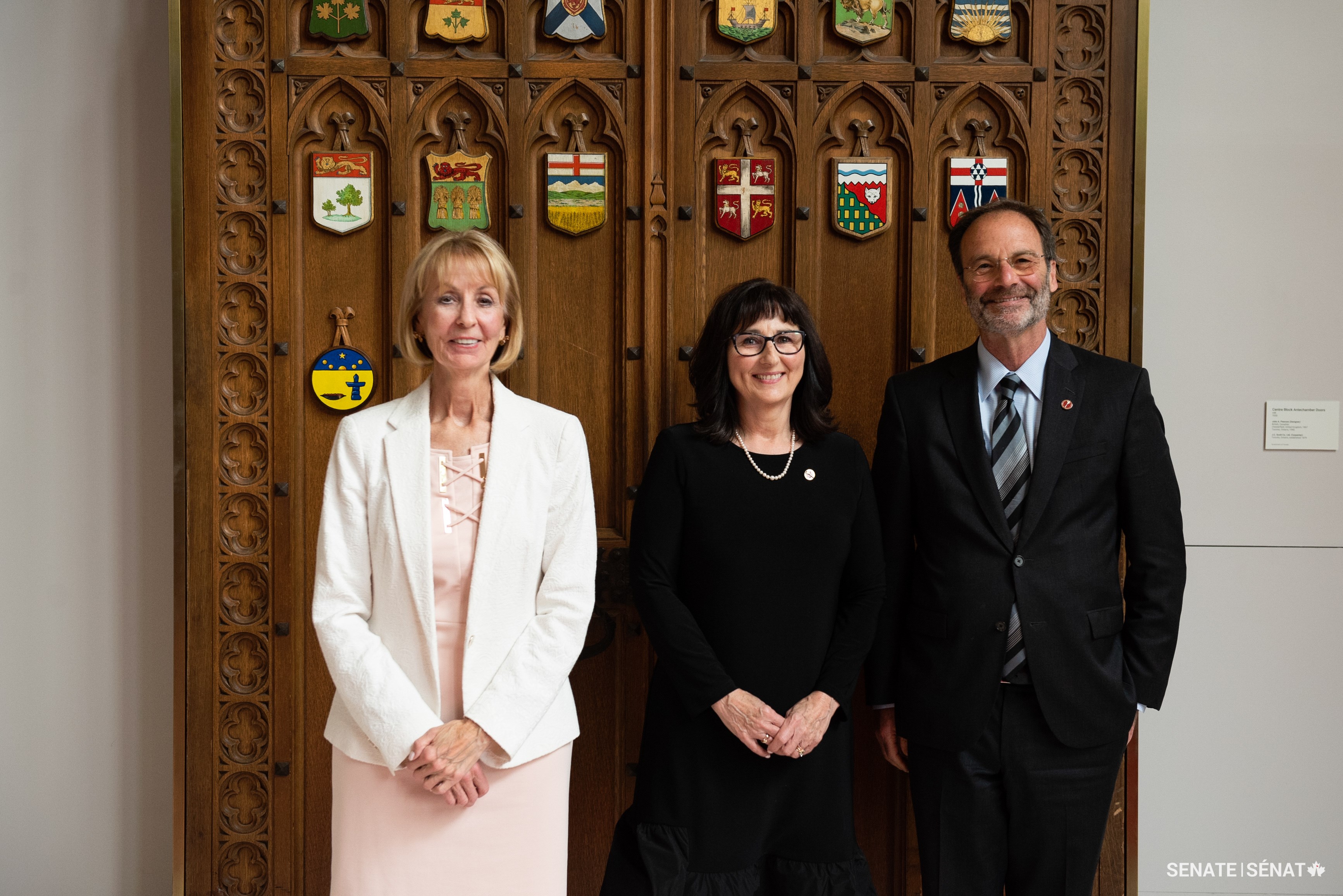 Senator Jane MacAdam, centre, poses outside the Red Chamber with senators Elizabeth Marshall and Marc Gold ahead of her swearing-in ceremony on June 6, 2023.