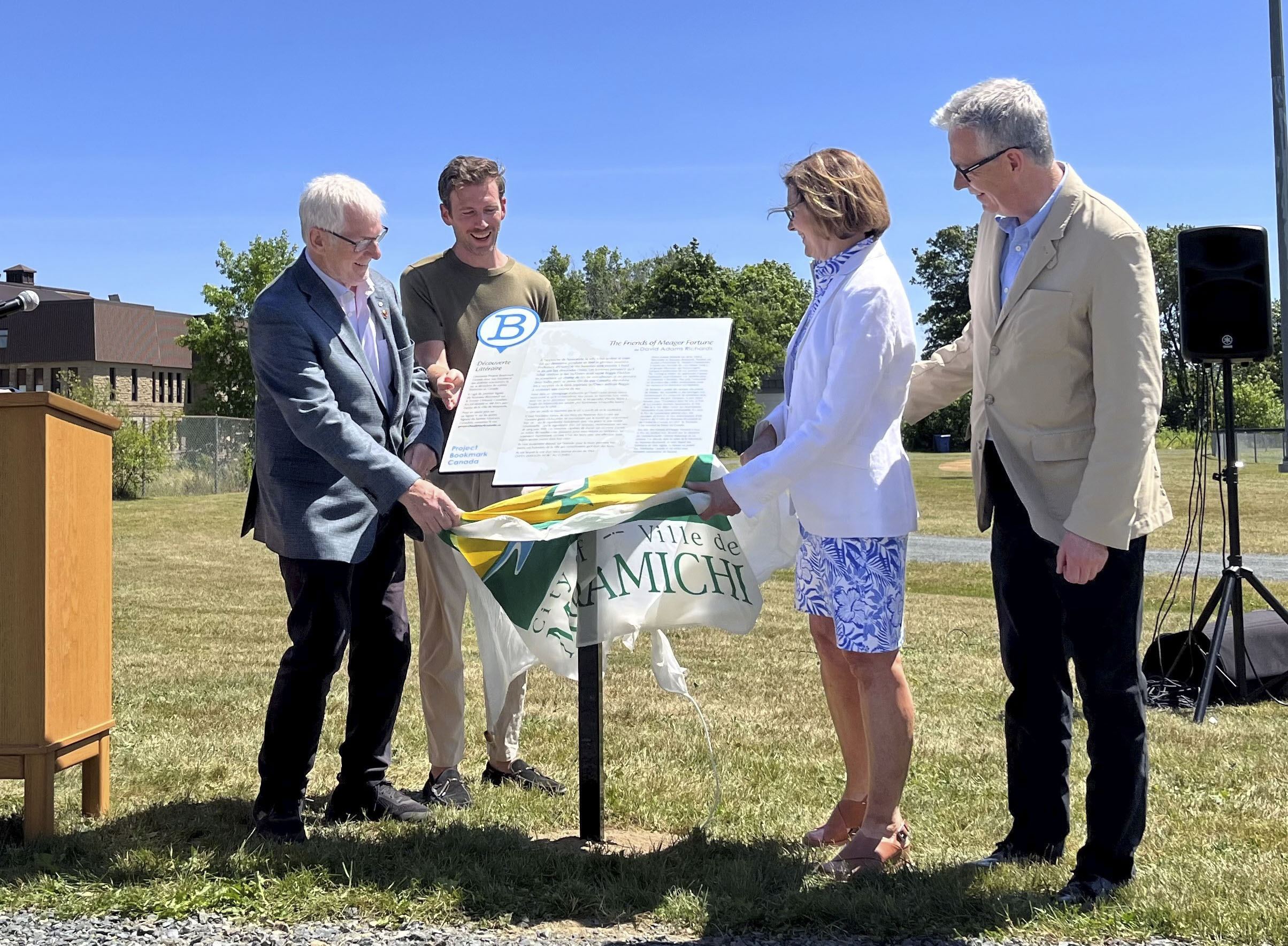 A group of four people unveil the first Canadian Literary Trail Bookmark plaque in New Brunswick.