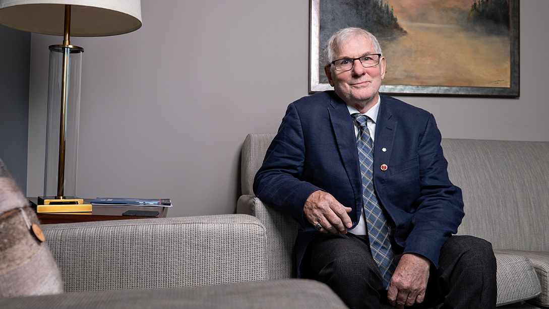 Senator David Adams Richards sitting on a sofa in his office.