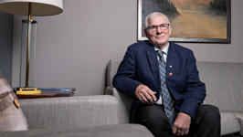Senator David Adams Richards sitting on a sofa in his office.