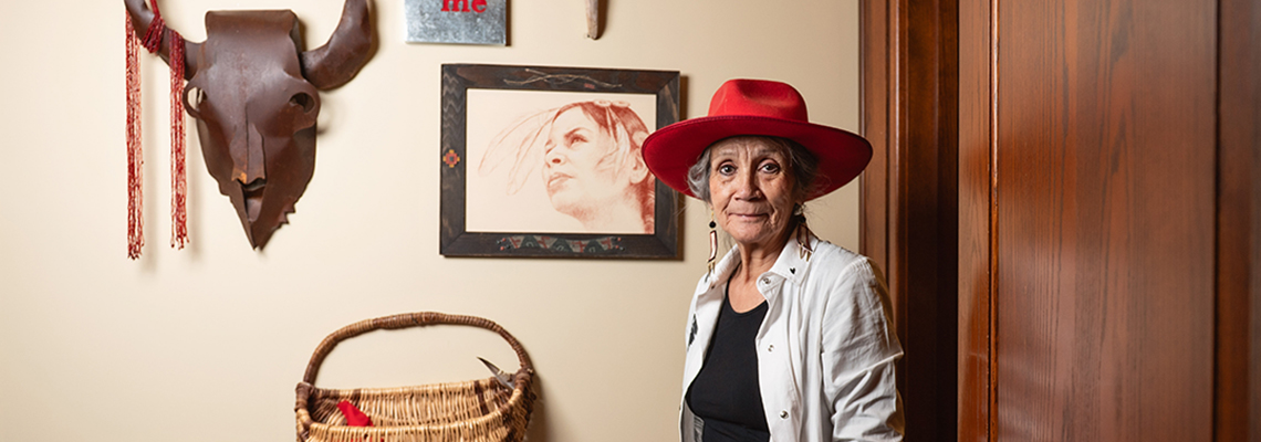 Senator Mary Jane McCallum stands before a wall of art in her office.