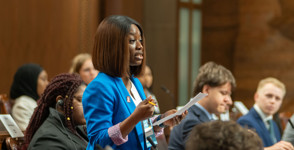Model senator Kazia Grace Macbruce stands at her desk in the Senate Chamber.