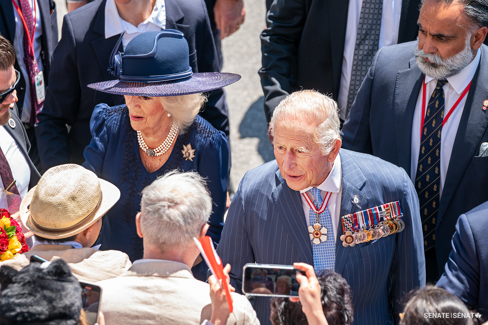 The King — wearing his Order of Canada insignia around his neck — greets well-wishers outside of the Senate of Canada Building after reading the throne speech. The King is Sovereign of the Order of Canada, which recognizes outstanding achievement, dedication to the community and service to the nation. Speaker Gagné — a member of the Order of Canada herself — also wore her Order of Manitoba insignia, which was presented to her by the King in 2014, when he was still Prince of Wales.