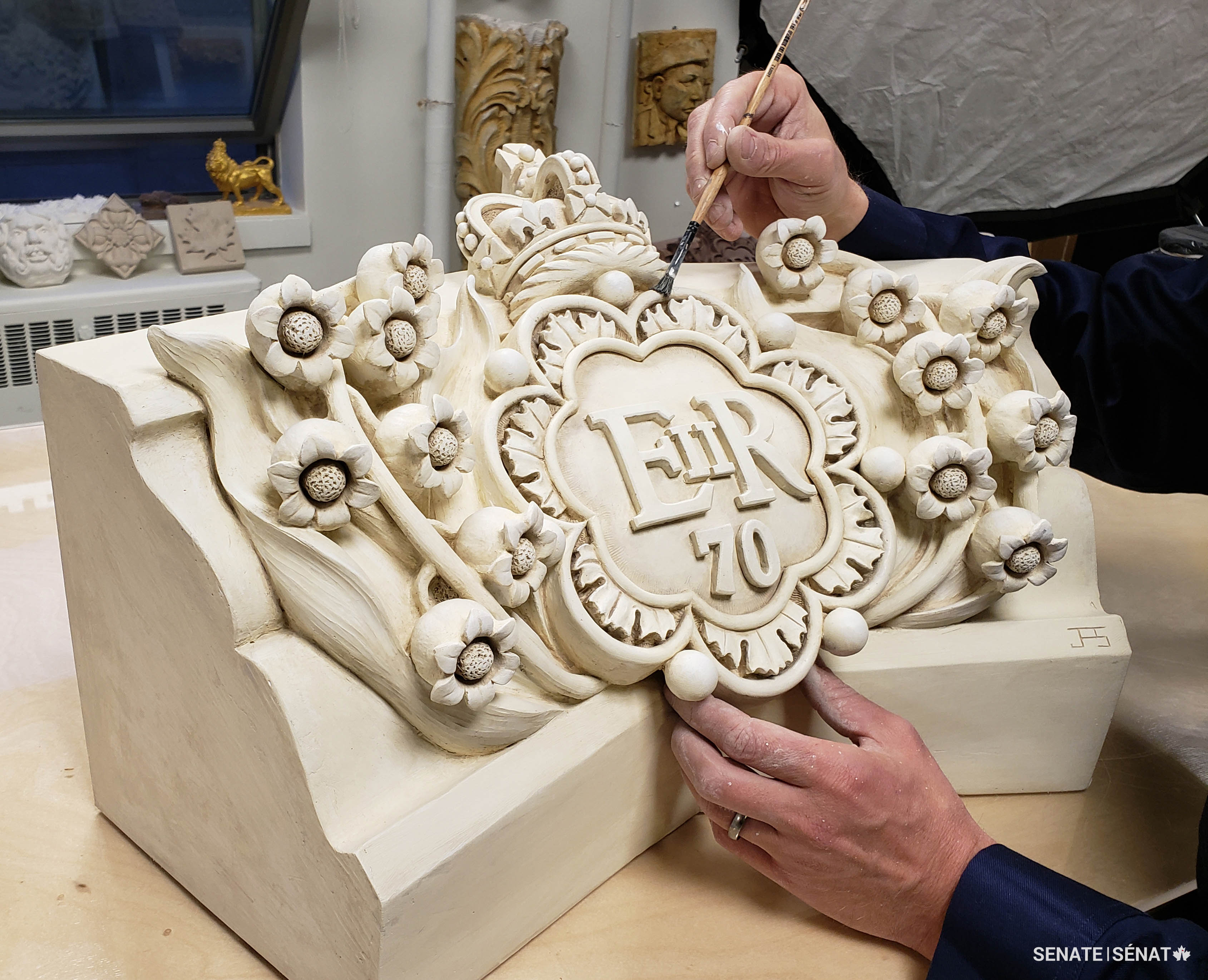 Mr. Smith adds a patina to the plaster maquette, giving it the appearance of real stone.