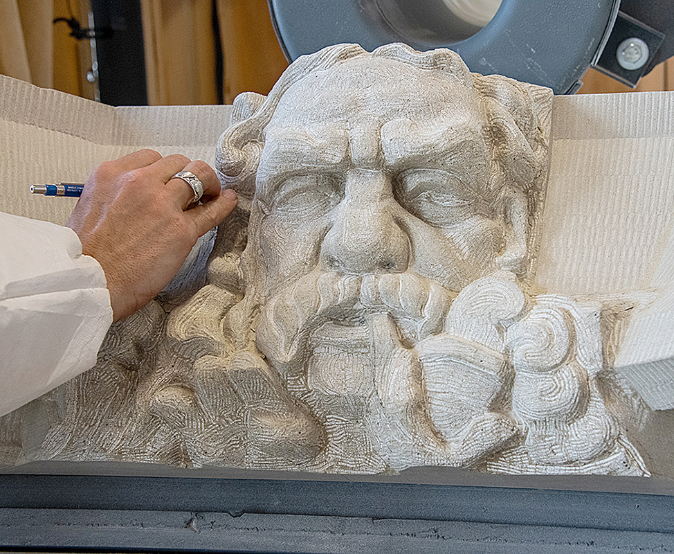 Mr. Thompson works with a fine chisel to refine details and add subtle textures to the nearly complete carving.