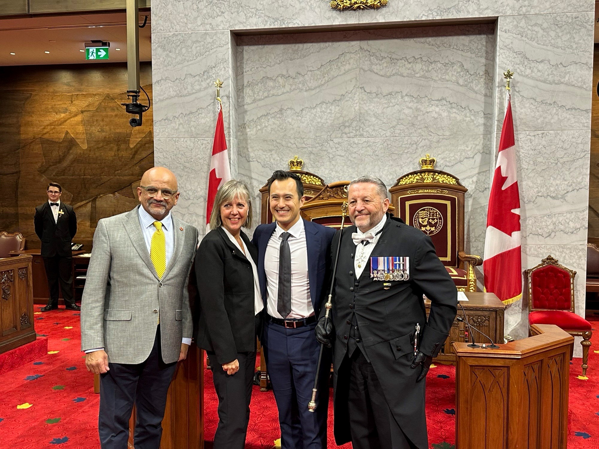 Wednesday, October 23, 2024 – From left: Senators Andrew Cardozo and Marty Deacon, Class of 2024 Order of Sport recipient, recipient of the Class of 2024 Order of Sport, Patrick Chan and the Usher of the Black Rod, J. Greg Peters; recognition of Patrick Chan in the Red Chamber; Senate of Canada Building, Ottawa, Ontario.