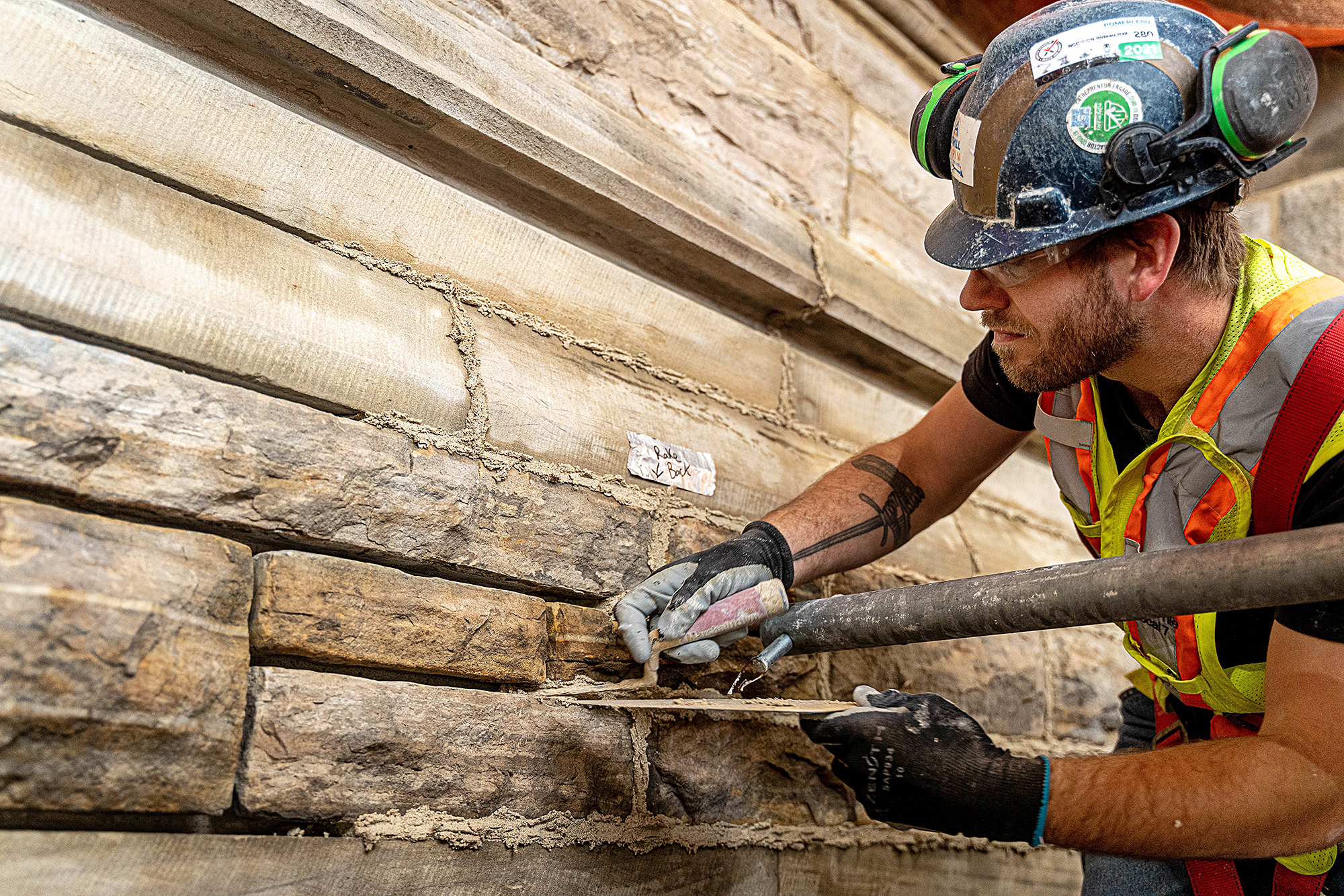 After the original mortar has been removed and repairs have been completed, a mason applies fresh mortar to the joints between stones, a process called repointing. (Photo credit: Public Services and Procurement Canada)