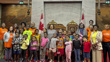 Senator Marie-Françoise Mégie poses with children from the Mosaïque Interculturelle Summer Camp in front of the Senate thrones.
