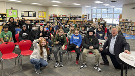 Senator Rob Black poses with students in a school library.